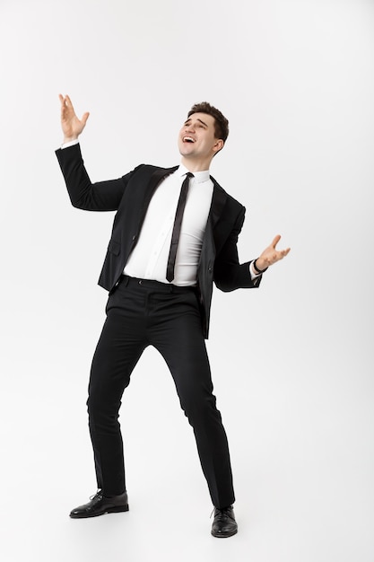 Business Concept - Handsome cheerful businessman showing hands in air over gray background.