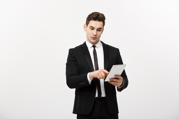 Бизнес-концепция: счастливый улыбающийся бизнесмен, указывая на цифровой планшет на белом фоне