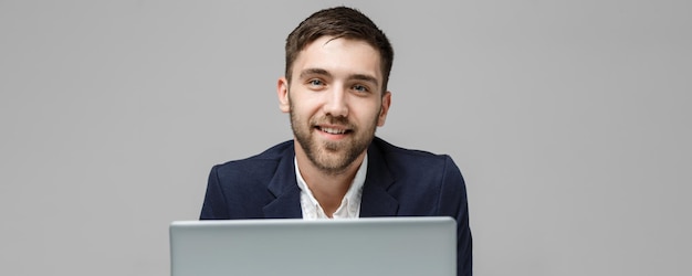 Foto gratuita ritratto di concetto di business bell'uomo d'affari che gioca con un notebook digitale con una faccia sorridente e sicura white backgroundcopy space