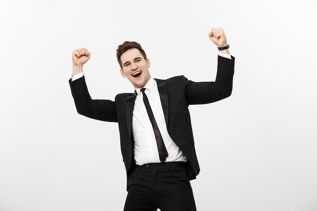 Business Concept: Portrait handsome businessman expressing surprise and joy raising his hands, isolated over white background.