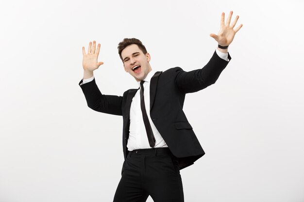 Business Concept: Portrait handsome businessman expressing surprise and joy raising his hands, isolated over white background.