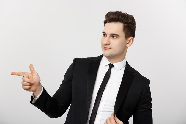 Business Concept: Portrait handsome young businessman point finger on side to empty copy space. Concept of advertisement product, isolated over white background