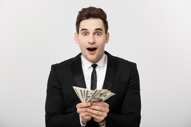 Business Concept: Portrait of shocked businessman showing a lot of money isolated over white background.