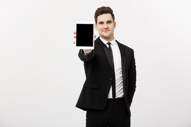 Business Concept: Smiling handsome businessman presenting website or presentation on tablet.