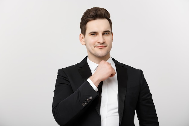 Business Concept: Smiling thoughtful handsome man standing on white isolated background and touching his chin with hand