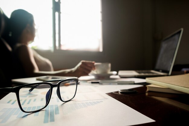 Business concept with copy space. Office desk table with pen focus and analysis chart, computer, notebook, cup of coffee on desk.Vintage tone Retro filter, selective focus.