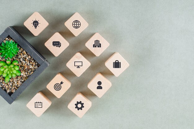 Бизнес-концепция с деревянными блоками с иконами, зеленым растением.