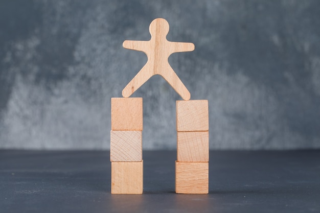 Business concept with wooden blocks with wooden human figure.