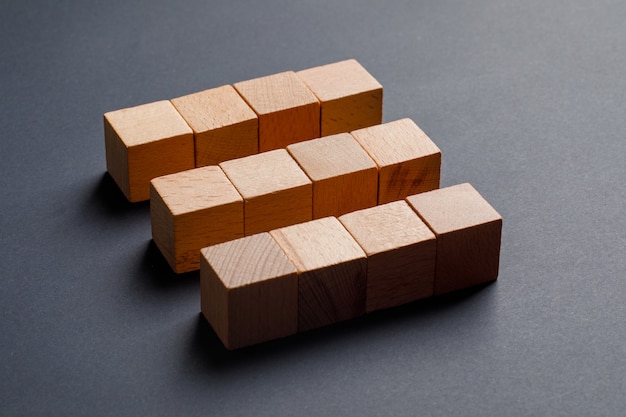 Free photo business concept with wooden cubes on dark grey table high angle view.