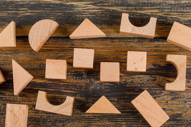 Business concept with wooden geometric shapes on wooden table flat lay.