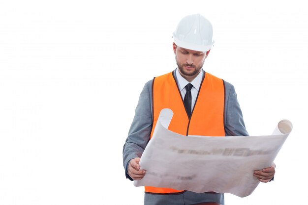 Business under construction. Professional male constructionist in a safety vest and helmet working on a building project