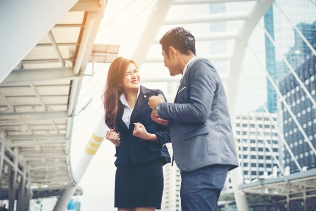 Business couple hands up doing yes outdoor. Concept of teamwork