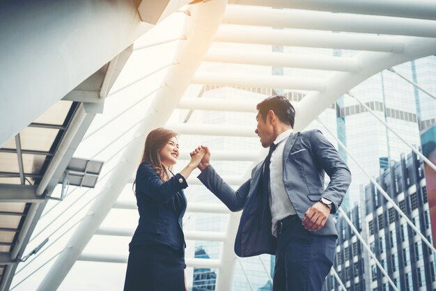 Business couple hands up doing yes outdoor. Concept of teamwork