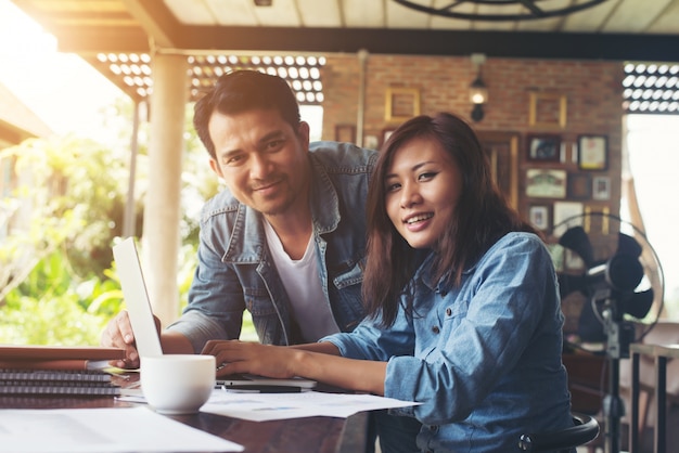 Business couple work with laptop together at cafe.