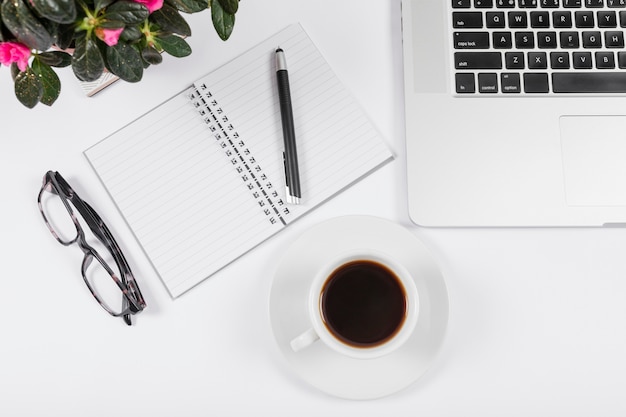 Business desk arrangement with empty notebook