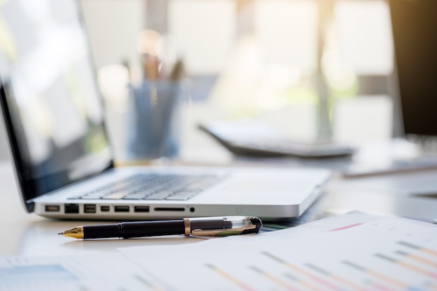 Free photo business desk with a keyboard, report graph chart, pen and tablet on white table