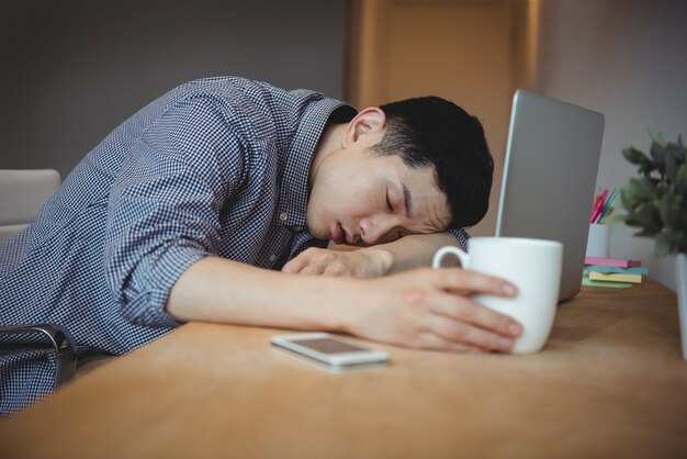 Business executive sleeping at his desk