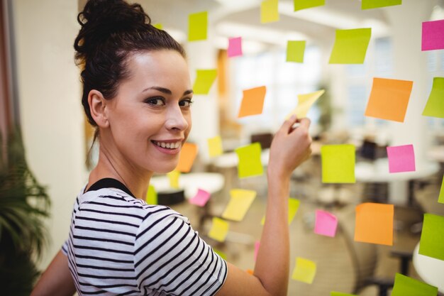 Business executive sticking sticky notes
