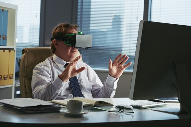 Business executive in VR headset in his office