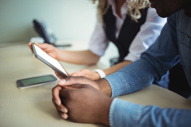 Business executives discussing over digital tablet