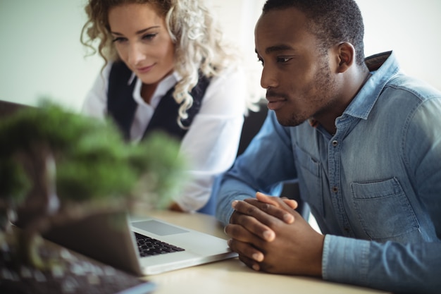 Business executives discussing over laptop