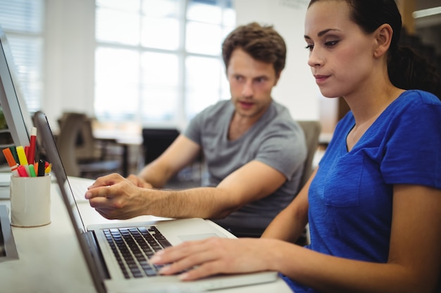 Foto gratuita i dirigenti aziendali che parlano sopra il computer portatile