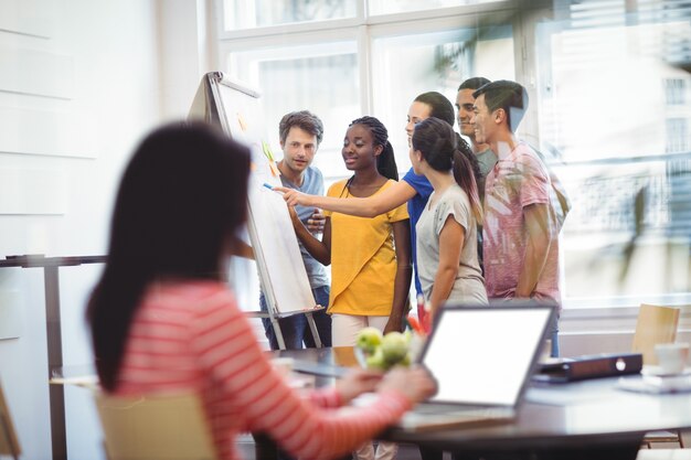 Business executives discussing on whiteboard