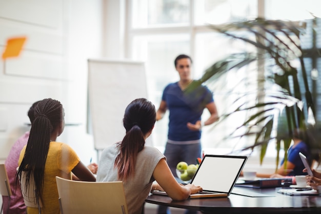 Business executives using laptop