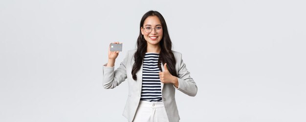 ビジネスファイナンスと雇用の起業家とお金の概念プロの女性銀行員のオフィスマネージャーは、thumbsupを示すクレジットカードバンキングサービスをお勧めします