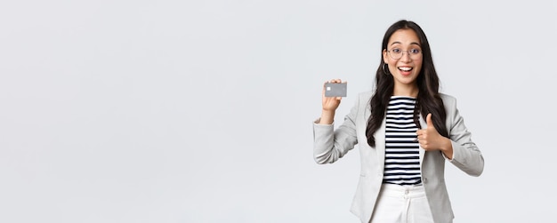 ビジネスファイナンスと雇用の起業家とお金の概念プロの女性銀行員のオフィスマネージャーは、thumbsupを示すクレジットカードバンキングサービスをお勧めします