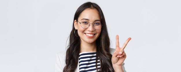 Business finance and employment female successful entrepreneurs concept Closeup of friendly outgoing asian office employee showing peace sign and smiling optimistic have all under control