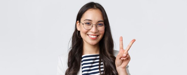 ビジネスファイナンスと雇用の女性の成功した起業家の概念平和の兆候を示し、楽観的な笑顔を示しているフレンドリーな発信アジアのオフィス従業員のクローズアップはすべて制御下にあります