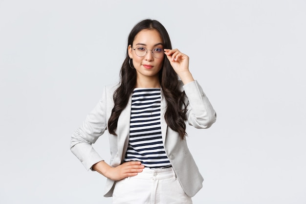 Free photo business, finance and employment, female successful entrepreneurs concept. confident businesswoman in glasses and white suit ready for meeting, smiling pleased, standing determined.