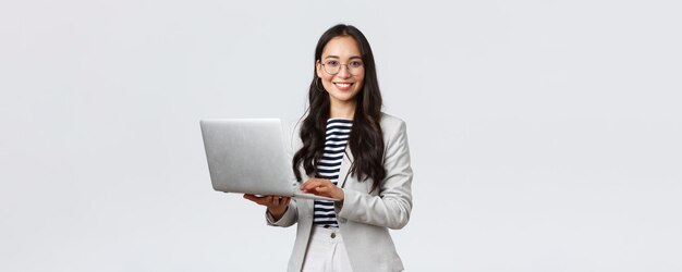 비즈니스 금융 및 고용 여성 성공적인 기업가 개념 흰색 양복을 입고 노트북을 사용하는 안경을 쓴 자신감 있는 웃는 아시아 여성 사업가