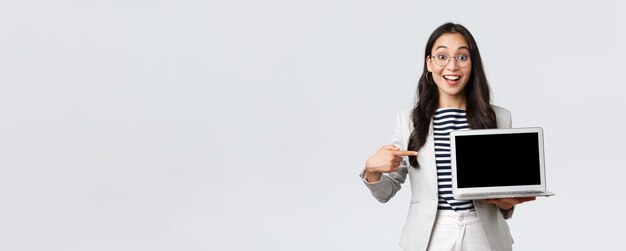 Business finance and employment female successful entrepreneurs concept Enthusiastic office manager showing her presentation on laptop pointing at screen and smiling amused