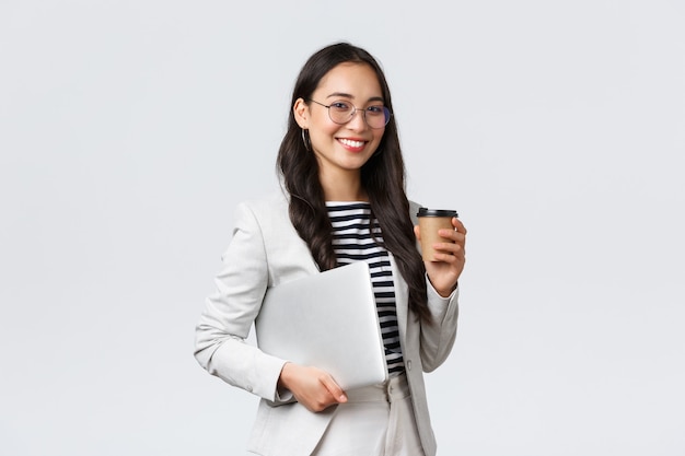 Business, finance and employment, female successful entrepreneurs concept. Professional confident asian real estate broker drinking coffee and carry laptop, on her way to next client
