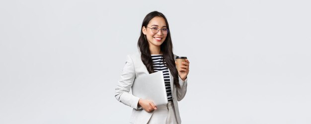Business finance and employment female successful entrepreneurs concept Professional confident asian real estate broker drinking coffee and carry laptop on her way to next client