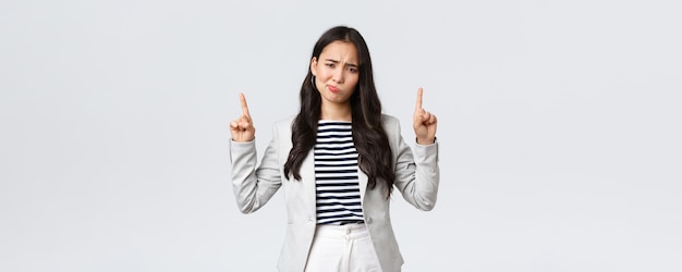 Business finance and employment female successful entrepreneurs concept Skeptical and disappointed businesswoman asian office lady grimacing displeased and pointing fingers up