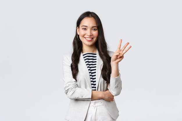 Business, finance and employment, female successful entrepreneurs concept. Successful female businesswoman, asian real estate broker pointing finger, showing number three and smiling