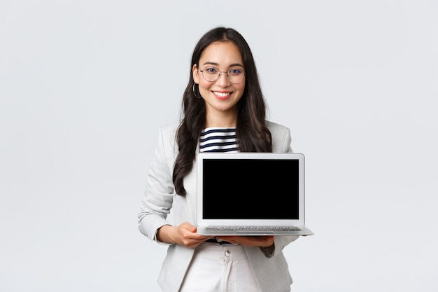 Business, finance and employment, female successful entrepreneurs concept. Talented real estate broker showing location to clients on laptop screen, having meeting with coworkers at office