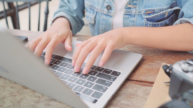 ビジネスフリーランスアジアの女性が働いて、プロジェクトをやって、カフェのテーブルの上に座っている間ラップトップまたはコンピューターに電子メールを送信します。コーヒーショップのコンセプトで働いているライフスタイルスマート美しい女性。