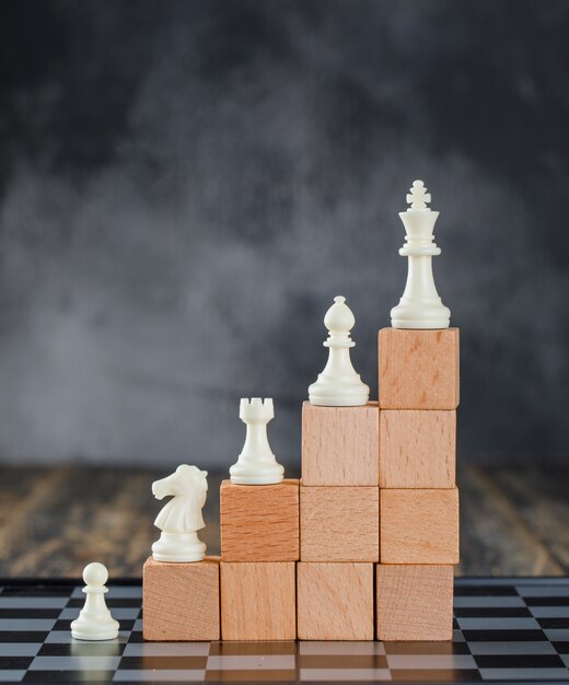 체스 판, 안개와 나무 테이블 측면보기에 나무 블록의 피라미드에 수치와 비즈니스 계층 개념.