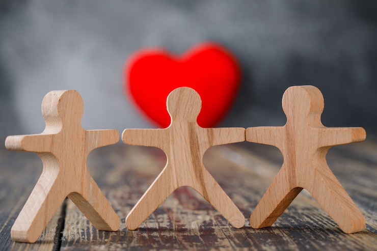 Free Photo business and insurance concept with wooden figures of people, red heart close-up.