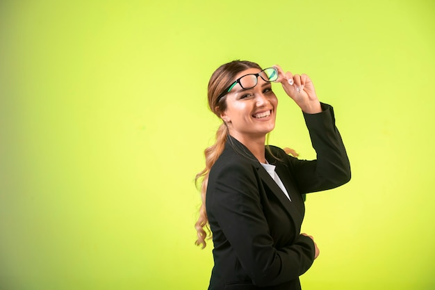 Business lady in black blazer and eyeglasses looks positive