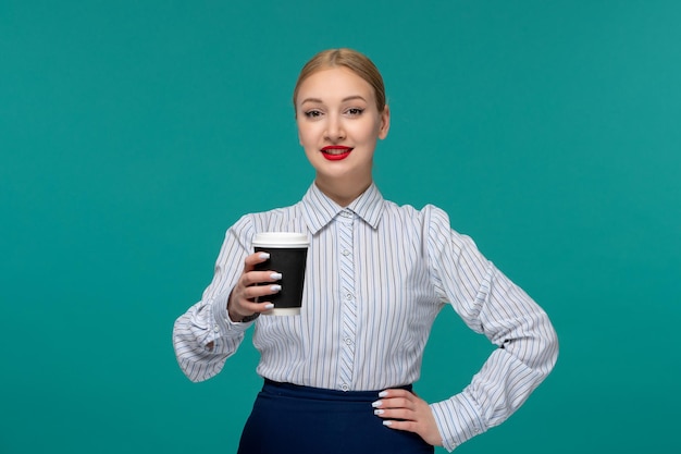 ビジネスレディかわいい若いブロンドの女性のオフィスの衣装とコーヒーカップを保持しているメガネ