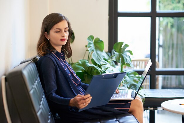 Business lady with laptop and clipboard