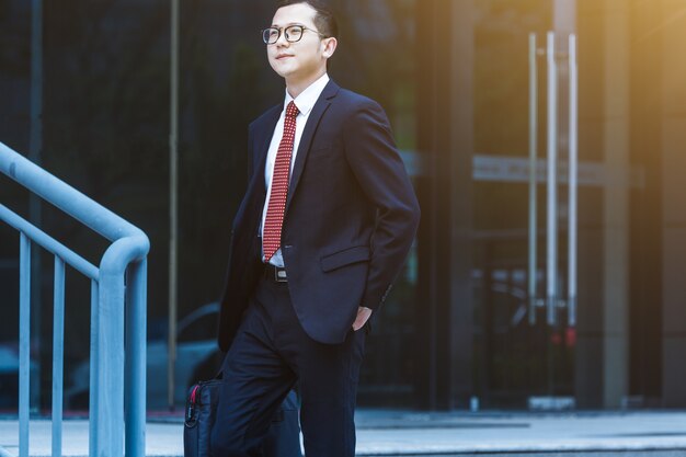 The business man carried his laptop in front of the office building