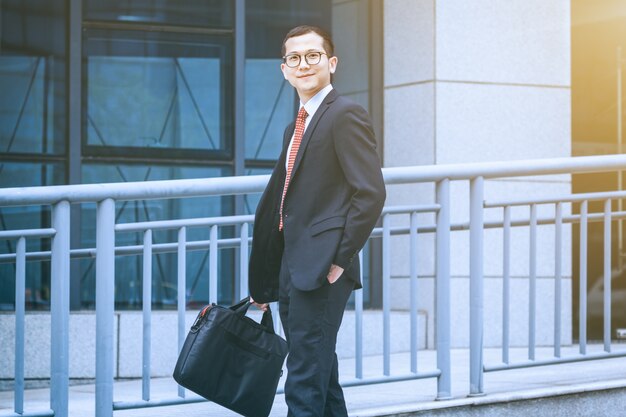 The business man carried his laptop in front of the office building