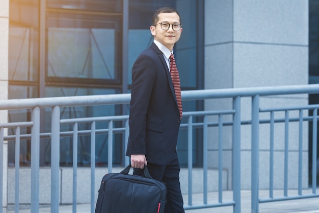 The business man carried his laptop in front of the office building