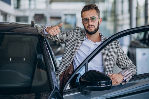 Деловой человек выбирает автомобиль в автосалоне